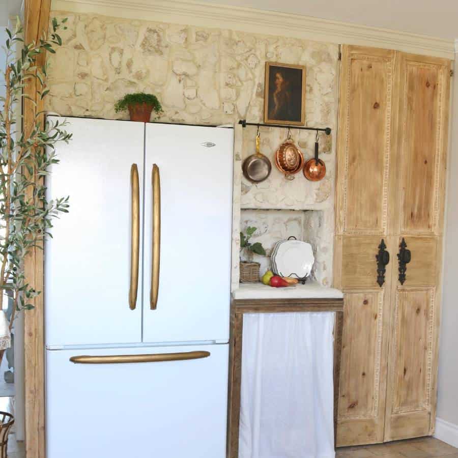 rustic kitchen white fridge gold accents hanging pans 