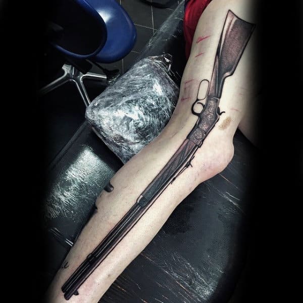 Large Rifle Tattoo In Black And Grey On Mans Arm