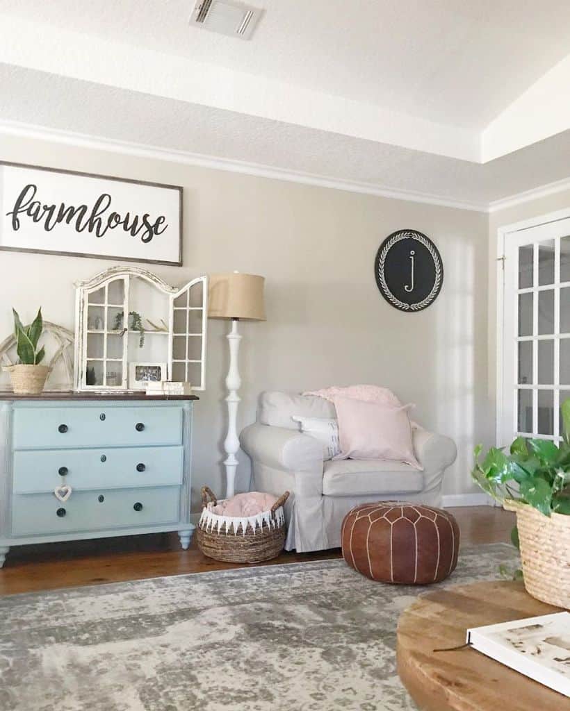 vintage farmhouse living room with blue chest of draws and gray armchair 