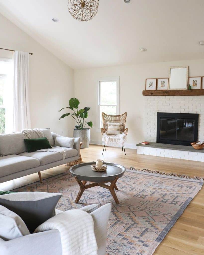 farmhouse living room with gray sofas and white brick fireplace 