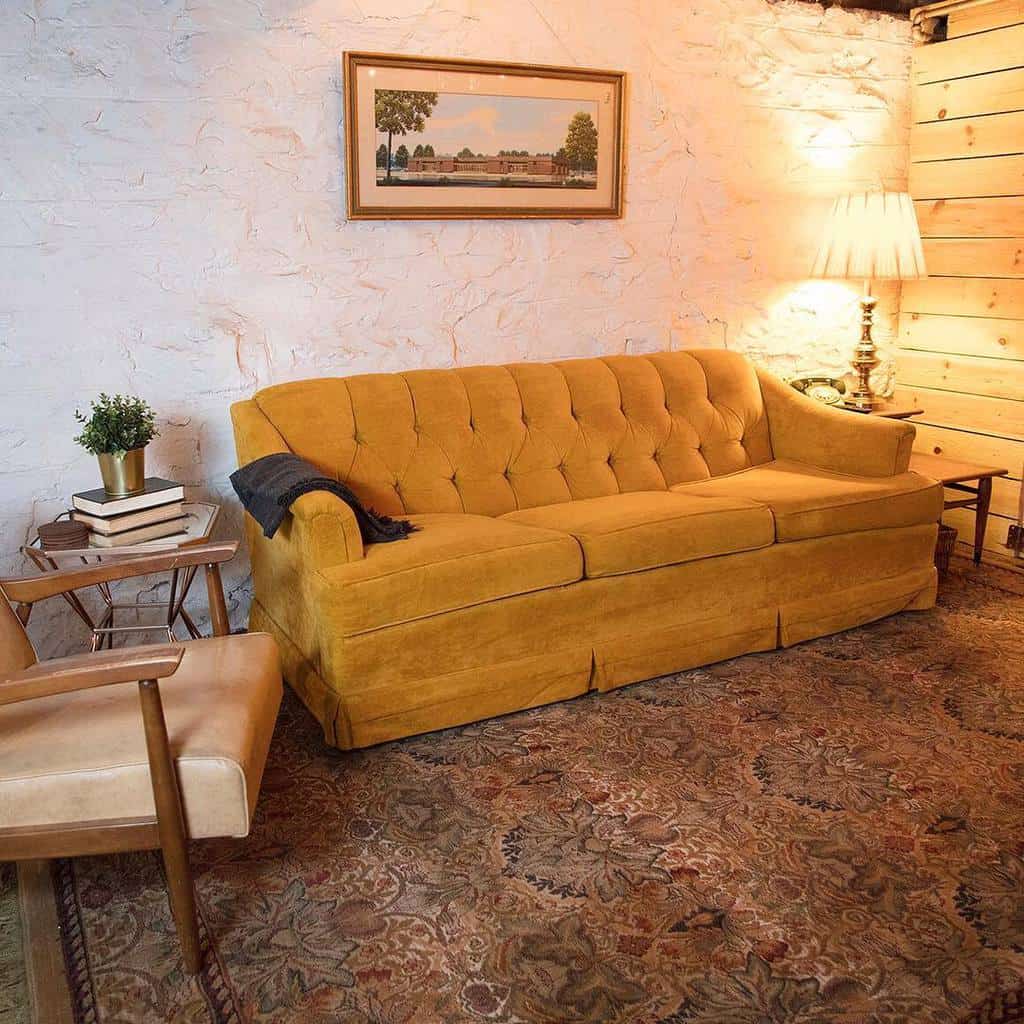 rustic basement living room with mustard sofa