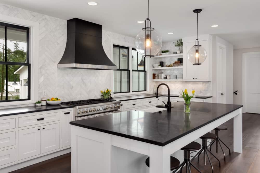 luxury white and black  farmhouse kitchen black countertops and stools pendant lights