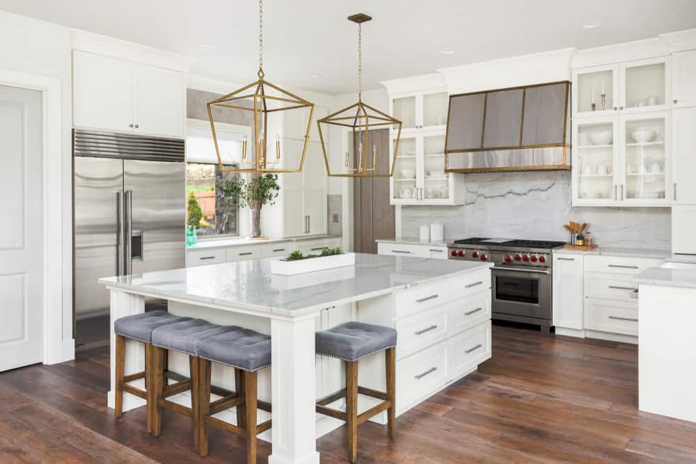 luxury farmhouse kitchen marble topped island hardwood floors white cabinets 