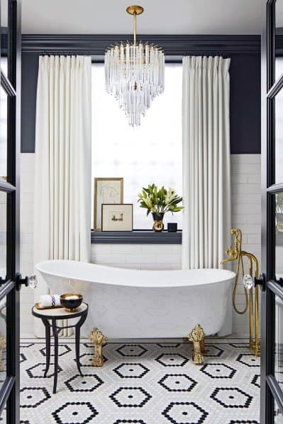 modern hotel style bathroom freestanding tub gold accents chandelier
