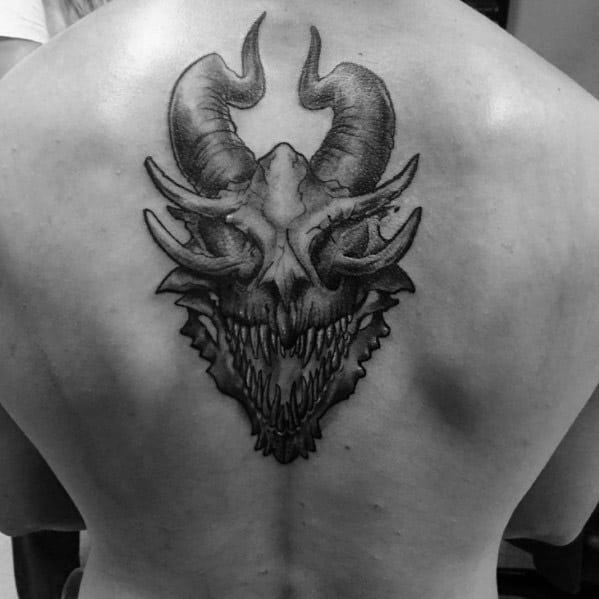 Male Tattoo With Dragon Skull Design On Upper Back