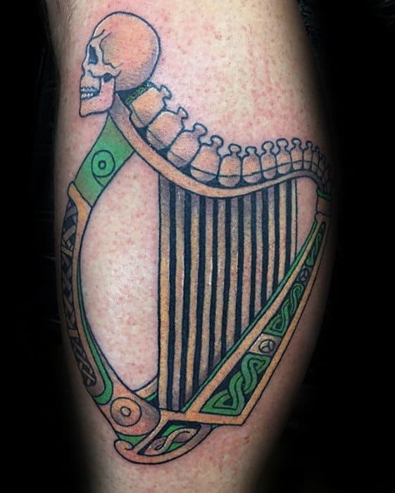 Male Tattoo With Harp And Skeleton Bones Design On Leg Calf