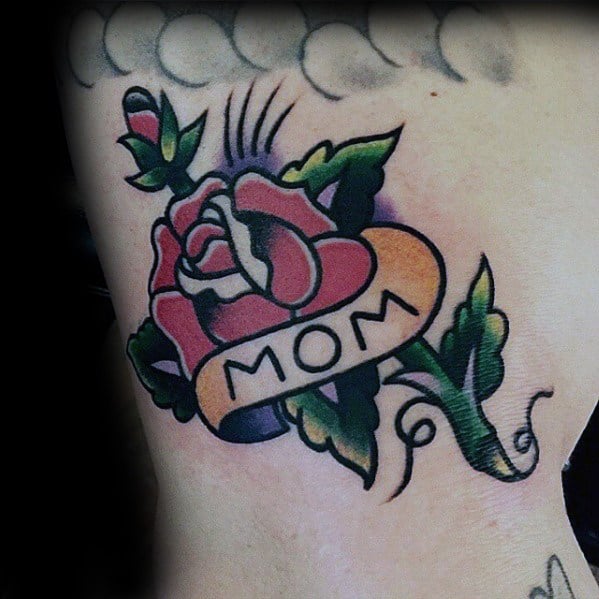 Male Tattoo With Traditional Mom Flower And Banner Design On Outer Arm