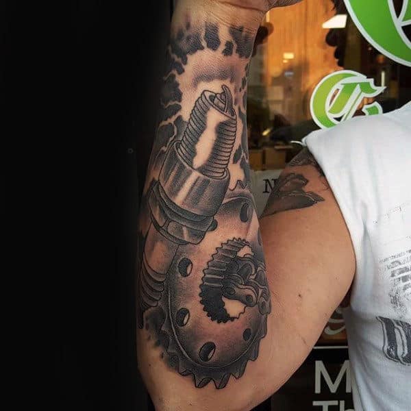 Male With Gear And Spark Plug Biker Tattoo On Forearm