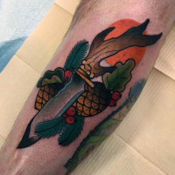Male With Tattoo Of Neo Traditional Dagger And Acorns On Leg