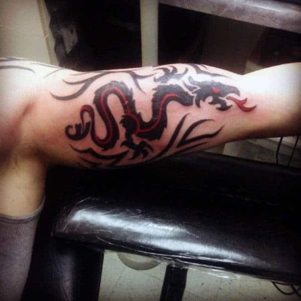 Male With Tribal Dragon Head Tattoos On Bicep