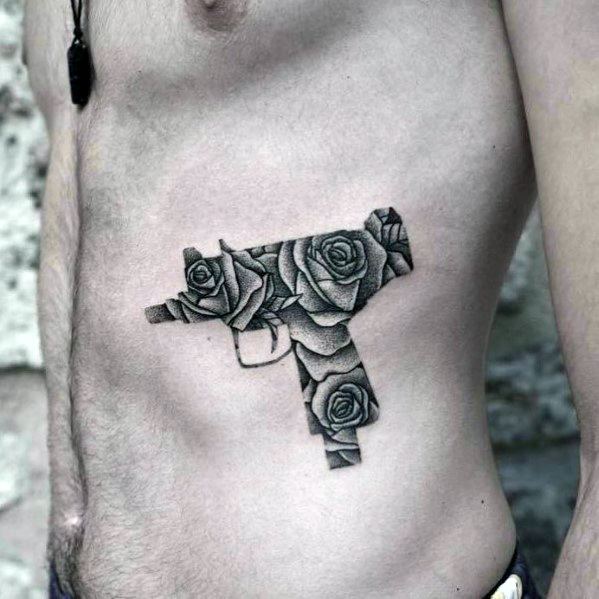 Male With Uzi Gun Ribs Tattoos