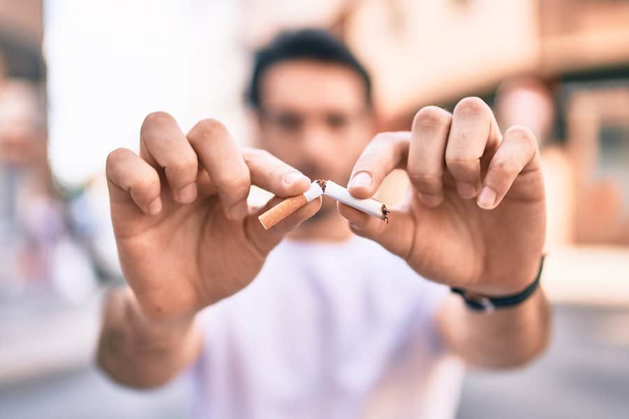 man breaking cigarette with hands