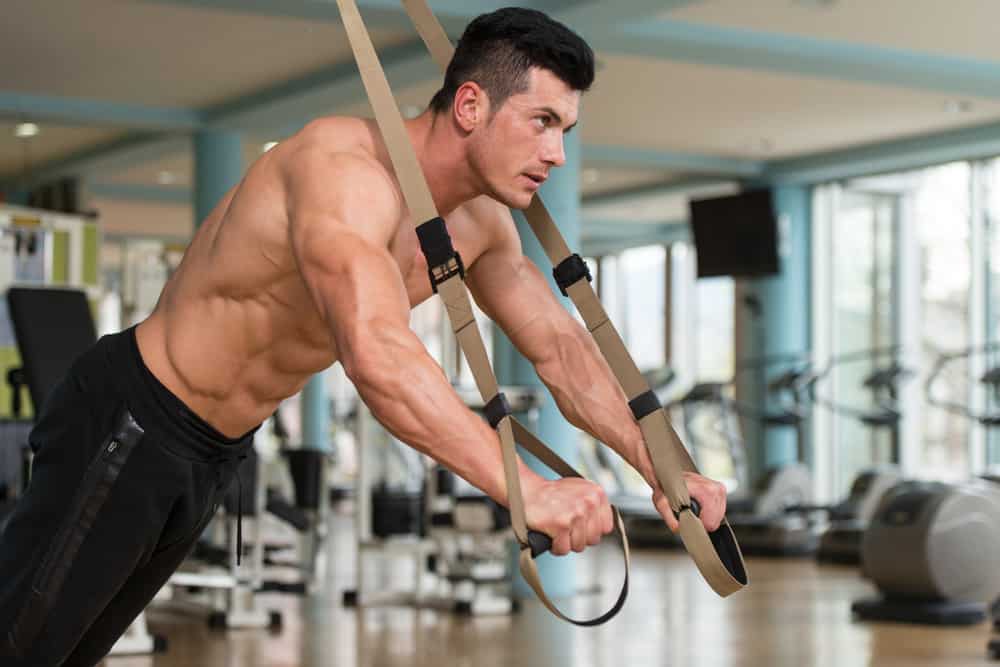 man does crossfit push ups with trx fitness straps