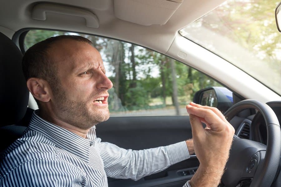man gesturing funny while driving