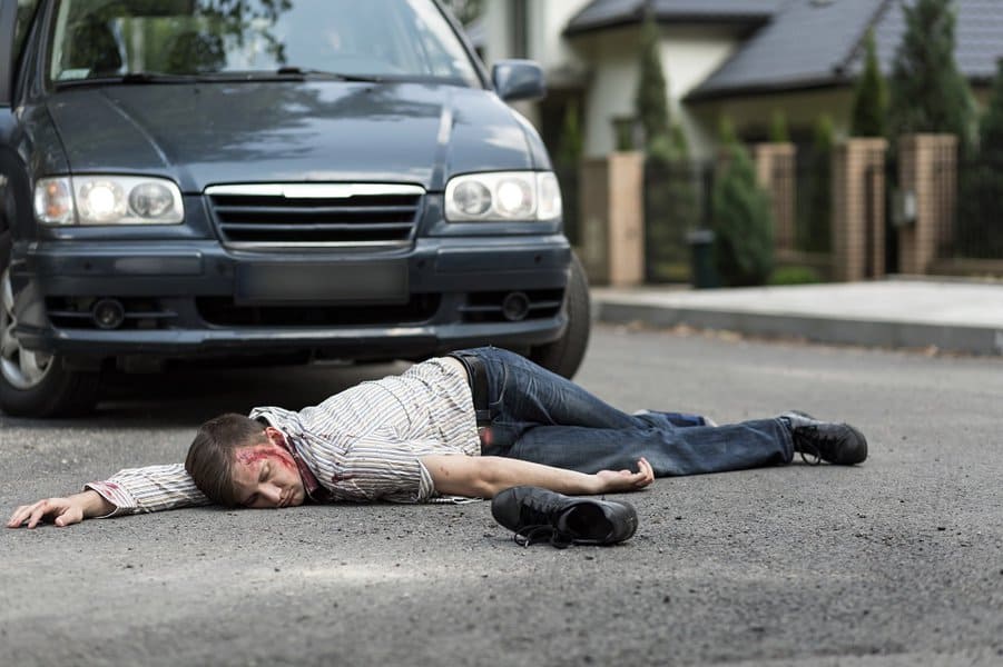 man hit by a car lying on the street