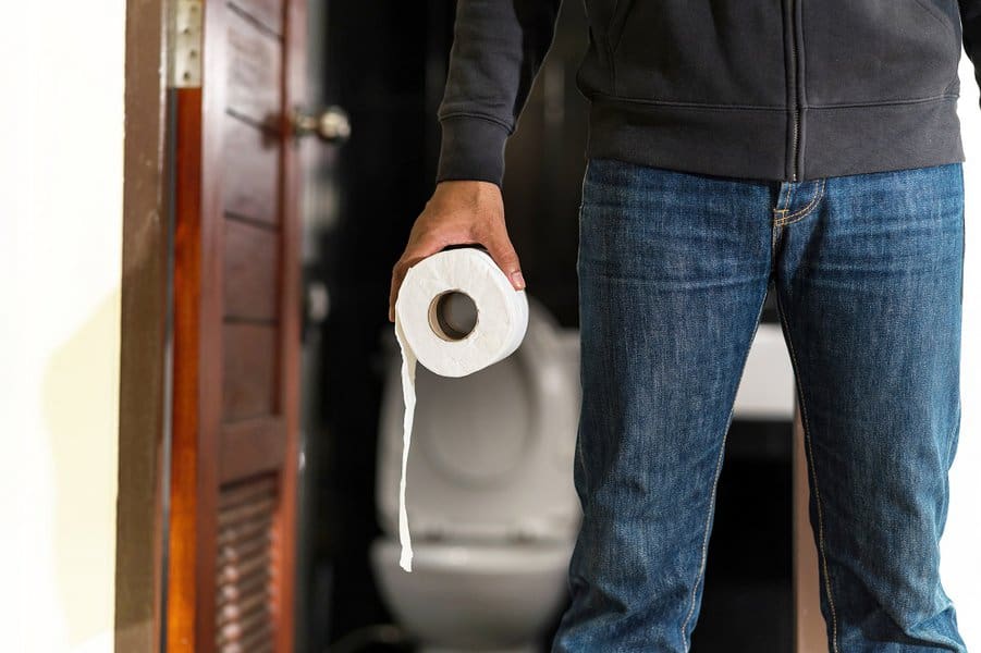 man holding tissue paper after using the toilet