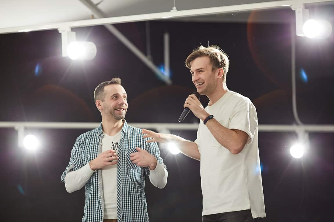 man show host presenting man on stage with trivia question