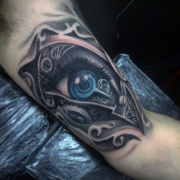 Man With Bicep Steampunk Styled Blue Eye Tattoo Design