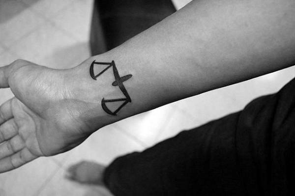 Man With Black Ink Libra Symbol Wrist Tattoos
