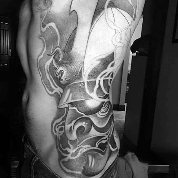 Man With Black Work Shaded Samurai Mask And Demon Side Piece Tattoo