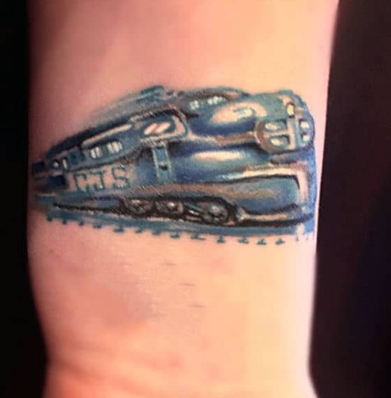 Man With Blue Rolling Train Tattoo On Wrist