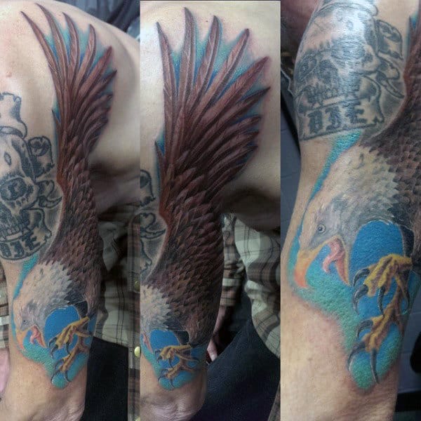 Man With Brown Feathered Bald Eagle Tattoo And Skull