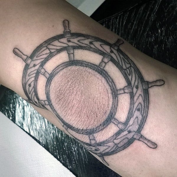 Man With Elbow Tattoo Of Nautical Ship Steering Wheel