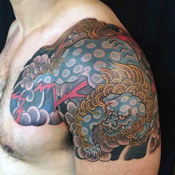 Man With Foo Dog Shoulder And Upepr Arm Tattoo