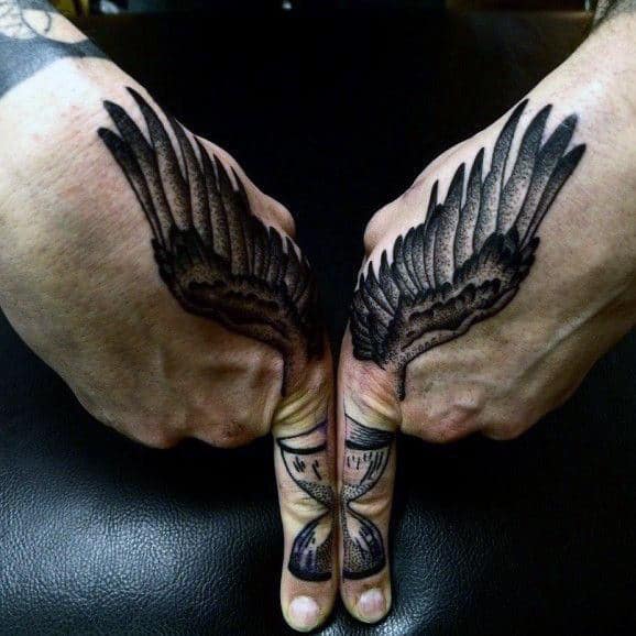 Man With Hourglass With Wings Tattoo On Fingers And Hands