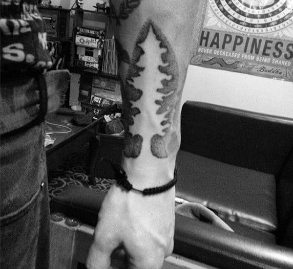 Man With Negative Space Tree Tattoo On Forearm