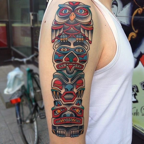 Man With Neo Traditional Totem Pole In Bright Color Upper Arm Tattoo