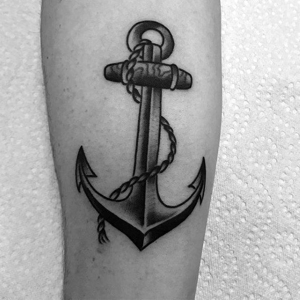 man with old school black and grey shaded inner forearm small anchor tattoo