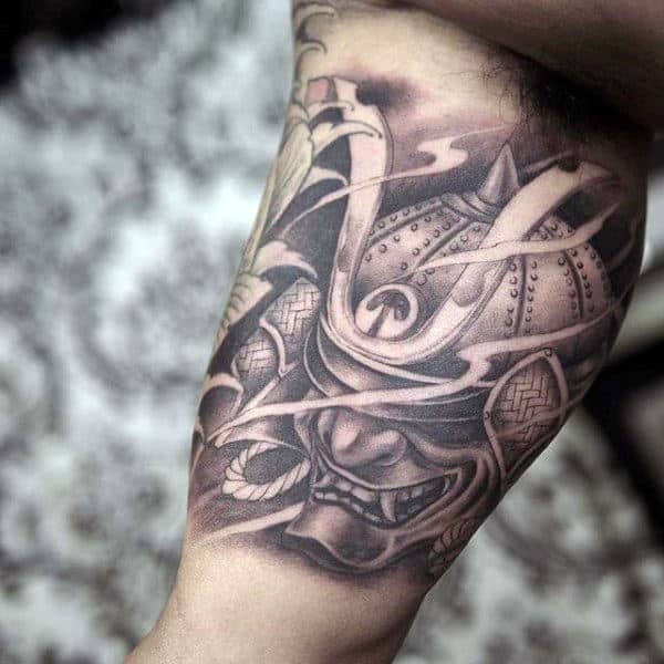 Man With Simple Shaded Samurai Mask Bicep Tattoo
