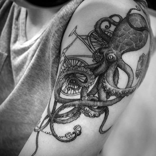 Man With Squiggly Reptile And Bicycle Tattoo On Arms