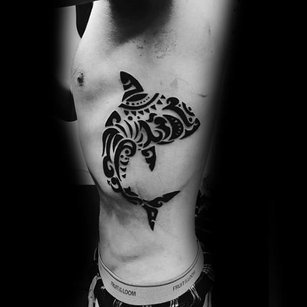 Man With Tattoo Of Black Ink Tribal Shark On Rib Cage With Hawaiian Design