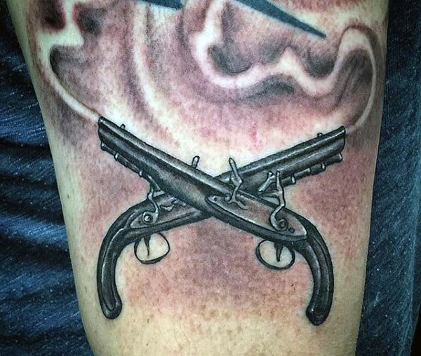 Man With Tattoo Of Guns Crossed