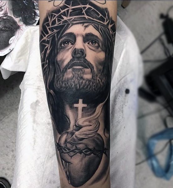 Man With Tattoo Of Jesus Holding Cross And Heart Forearm Sleeve