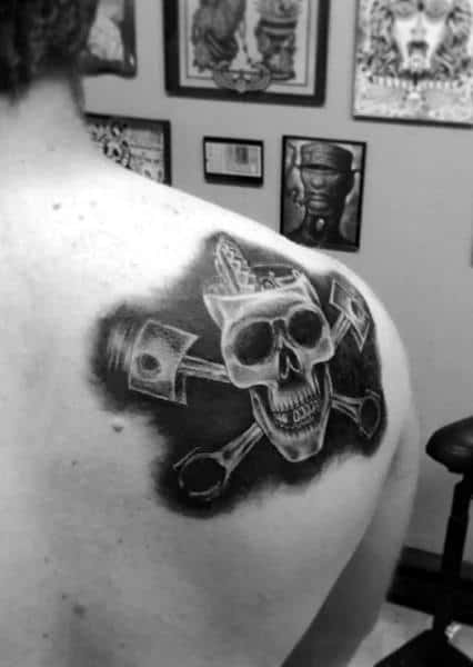 Man With Tattoo Of Piston Head And Skull On Back