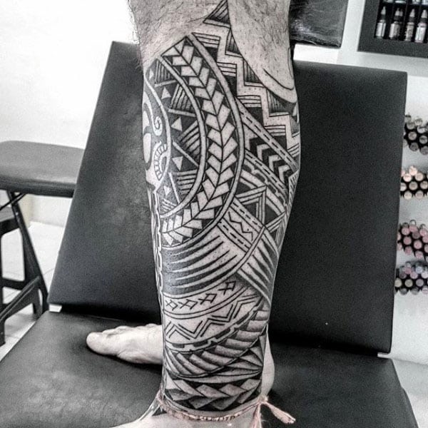 Man With Tattoo Of Polynesian Tribal Design On Legs