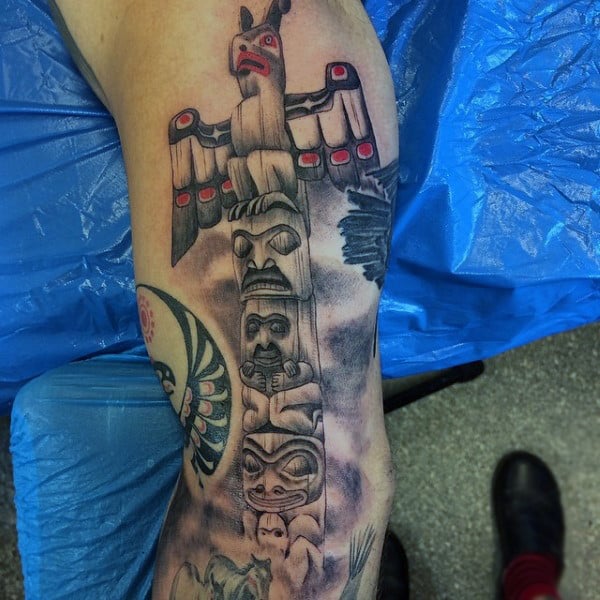 Man With Tattoo Of Realistic Totem Pole In Mist On Bicep