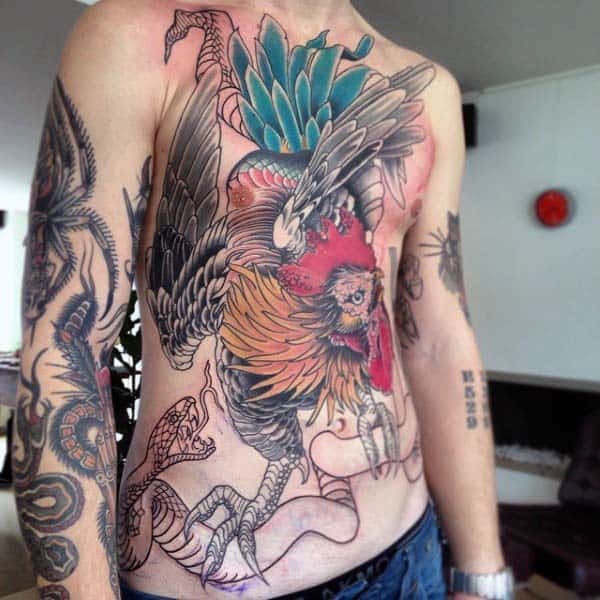 Man With Traditional Style Rooster Tattoo On Chest And Abs Fighting Snake.