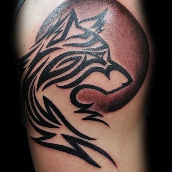 Man With Tribal Wolf And Shaded Moon Tattoo On Arm