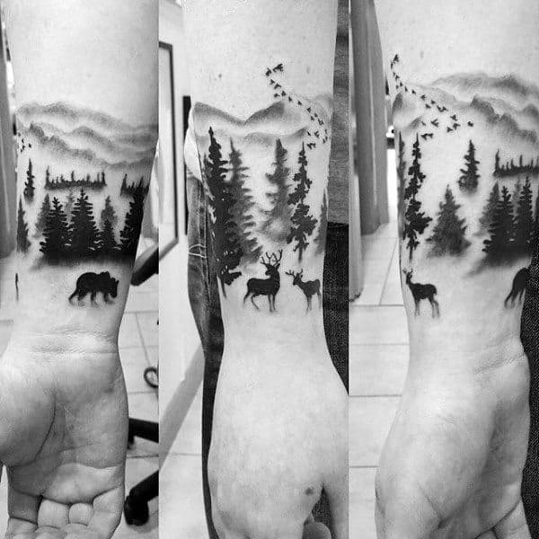 Man With Wrist Tattoo Of Forest And Wild Animals In Nature