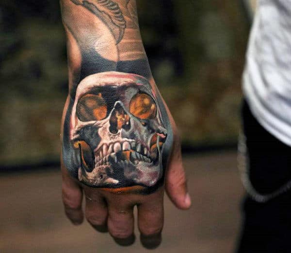 Manly Glowing Orange Skull Tattoo On Hand With White Ink
