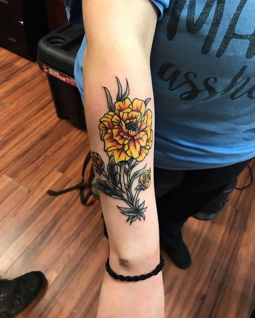 Watercolor style marigold tattoo located on the inner
