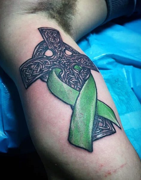 Mens Black Celtic Cross Tattoo With Green Ink Ribbon On Arm