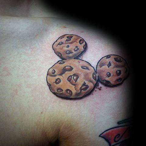 This fun tattoo features **chocolate chip cookies** arranged in the shape of **Mickey Mouse**, combining a love for sweets and Disney! 🍪🐭