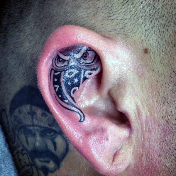 Skull With Roses Tattoo On Women Right Behind The Ear