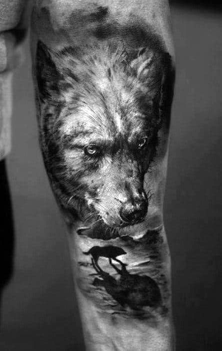 Black and grey wolf tattoo on the right upper arm in