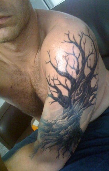 Circular tree tattoo on the right shoulder blade